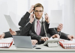 A business man with way too many arms is performing multiple tasks at once. This is a humorous depiction of multitasking 